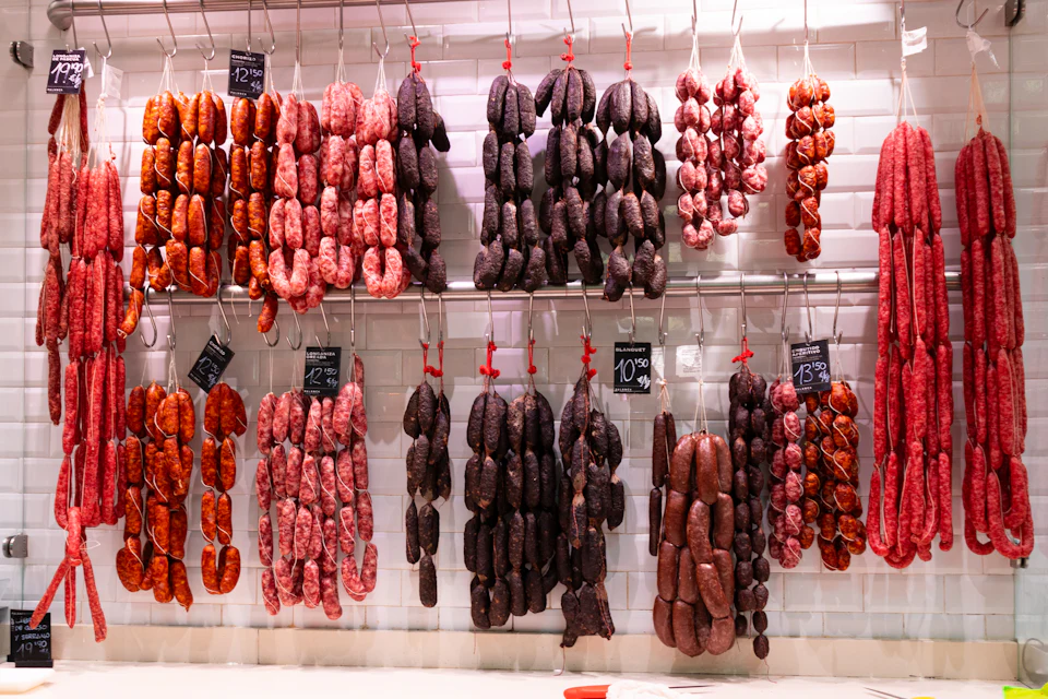 Enchidos pendurados em ganchos num balcão