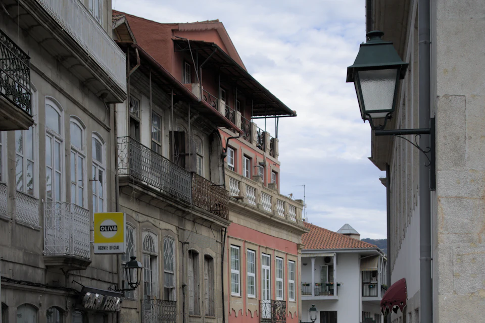 Rua do centro de Chaves com casas de varandas e pessoas a passear